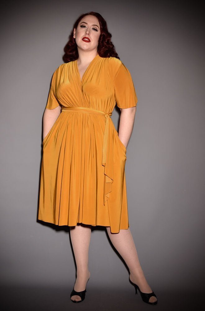 The Mustard Flutter Sleeve Claudia Dress is a draped jersey dress with sash waist. A signature piece for the Alexandra King for Deadly is the Female.