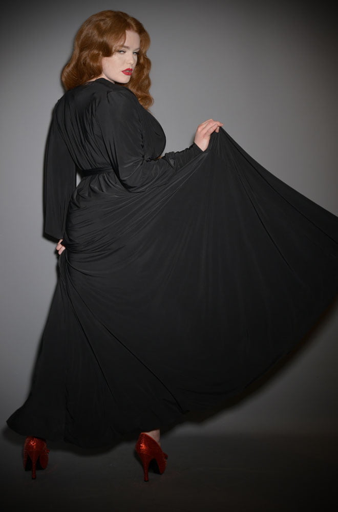The Black Claudia Gown is a draped jersey evening dress with sash waist & bishop sleeves. A signature piece by Alexandra King for Deadly is the Female.