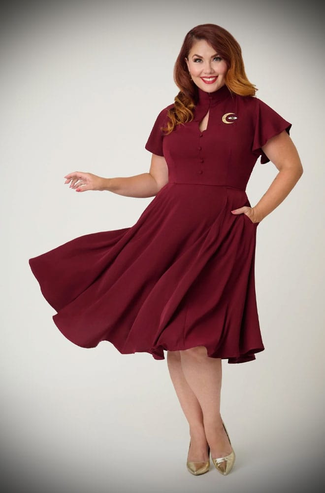 The Evil Eye Swing Dress is an elegant vintage-style dress in burgundy, featuring a stunning, mystic embroidery. A vintage-inspired dress for pinup girls.