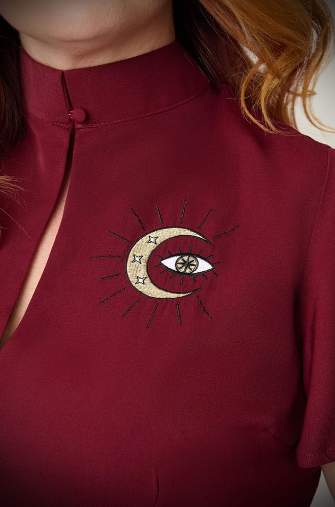 The Evil Eye Swing Dress is an elegant vintage-style dress in burgundy, featuring a stunning, mystic embroidery. A vintage-inspired dress for pinup girls.