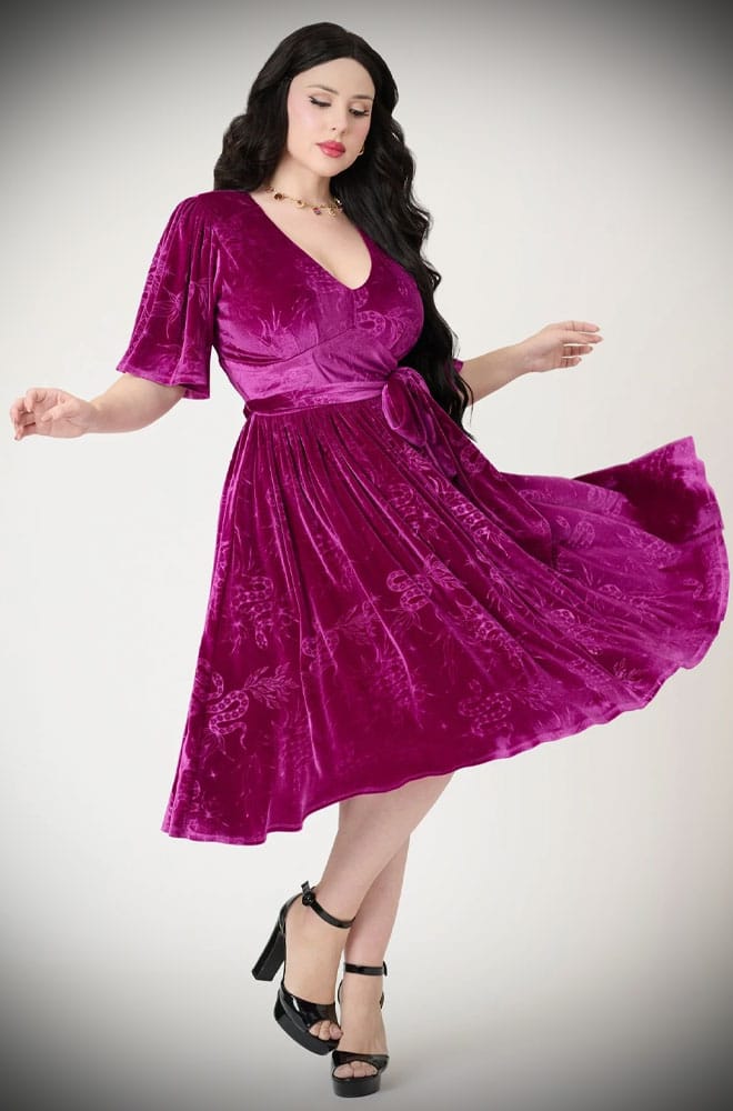 The Snake Velvet Swing Dress is a vintage-inspired dress in luxurious magenta velvet, with embossed snake details, with hidden pockets!