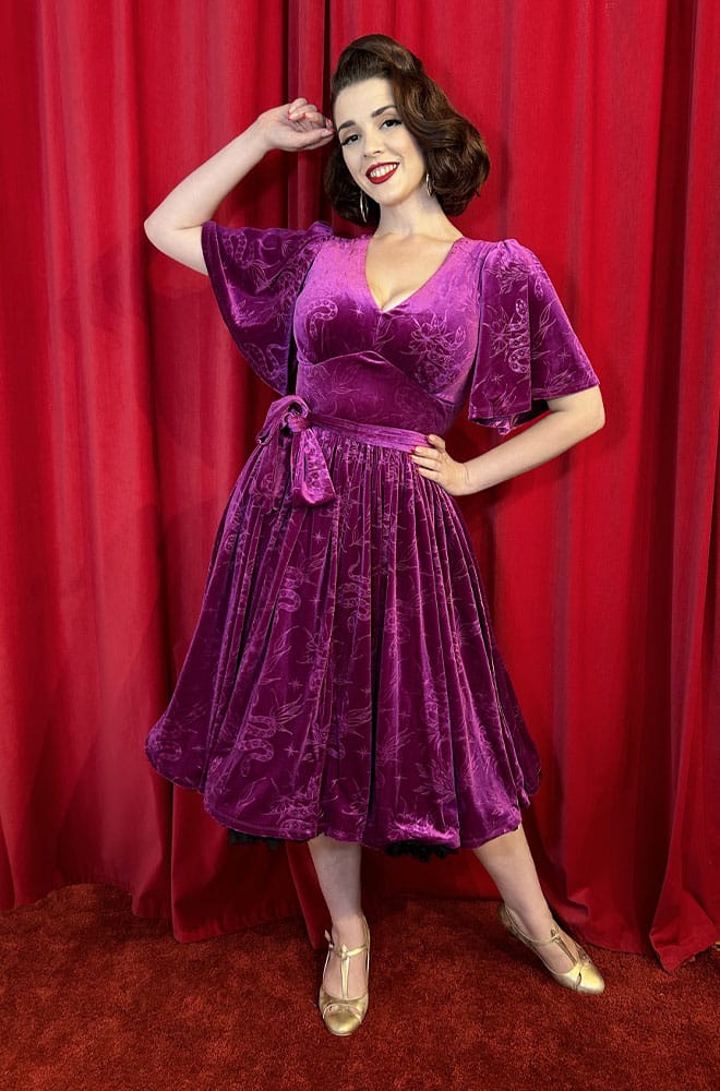 The Snake Velvet Swing Dress is a vintage-inspired dress in luxurious magenta velvet, with embossed snake details, with hidden pockets!
