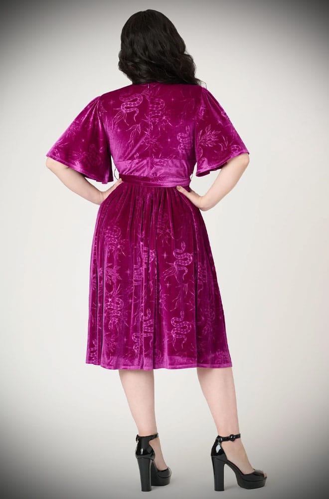 The Snake Velvet Swing Dress is a vintage-inspired dress in luxurious magenta velvet, with embossed snake details, with hidden pockets!
