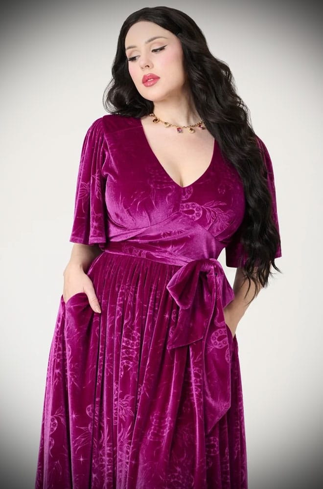The Snake Velvet Swing Dress is a vintage-inspired dress in luxurious magenta velvet, with embossed snake details, with hidden pockets!