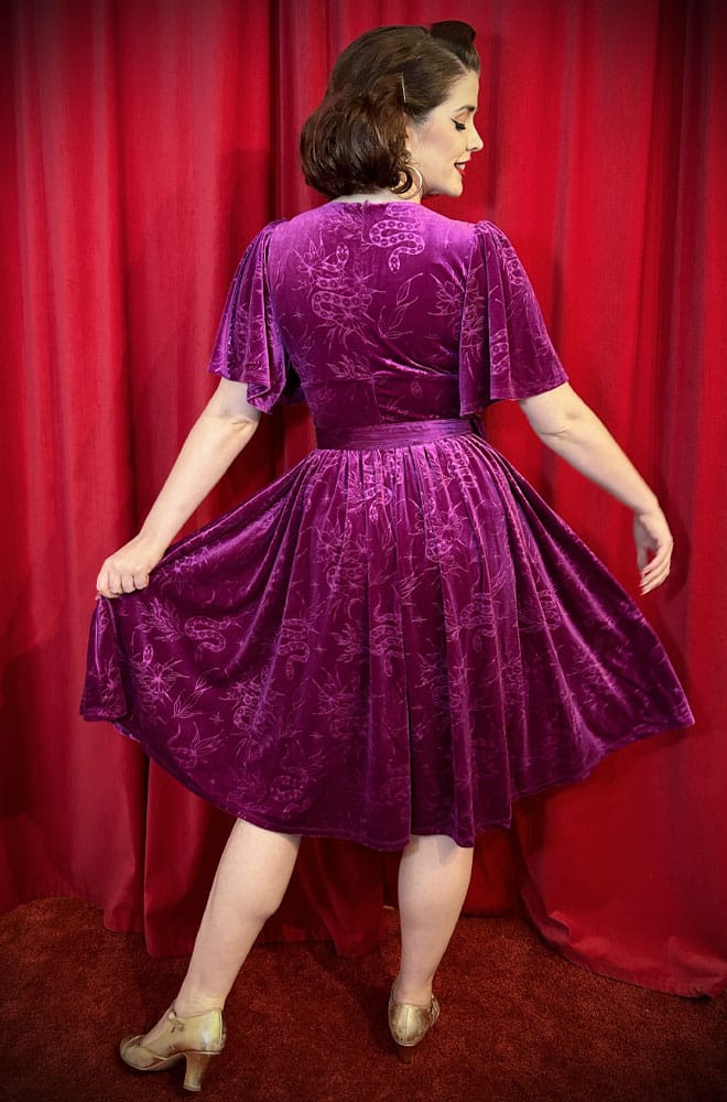 The Snake Velvet Swing Dress is a vintage-inspired dress in luxurious magenta velvet, with embossed snake details, with hidden pockets!