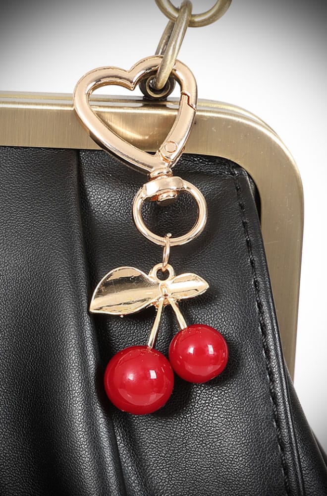 Add a touch of whimsy with Cherry Bag Charm! This adorable accessory features a vibrant cherry design on a golden heart-shaped keyring. Perfect for adding a pop of color and fun to your bags or keys. 